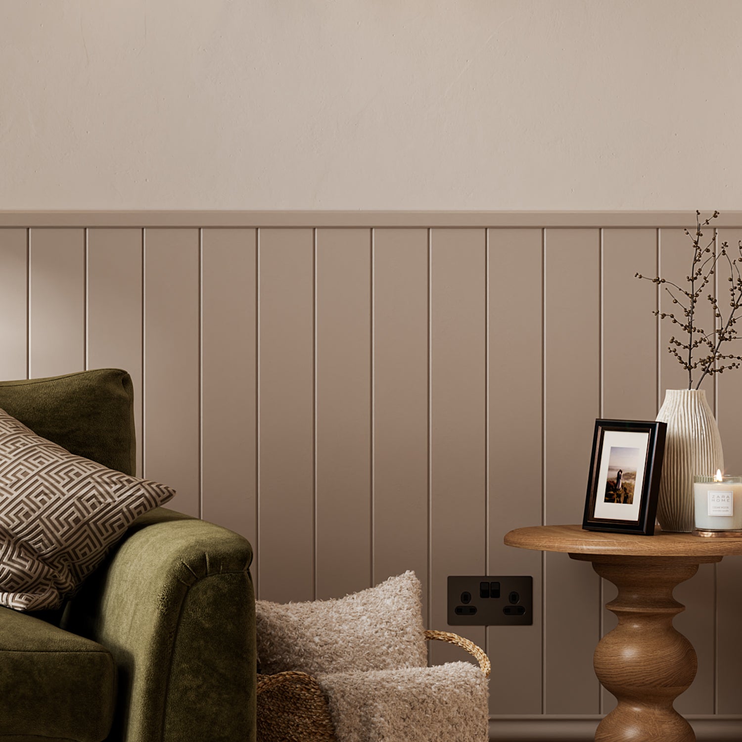 Nestled corner of a living room with a green sofa, wooden side table, and decorative items featuring wall panelling.